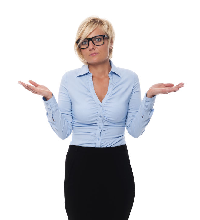 A woman with short blond hair, wearing glasses and a blue shirt, shrugs with both palms up, against a white background.